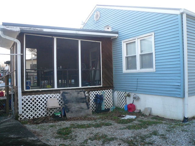 rear view of property featuring a sunroom