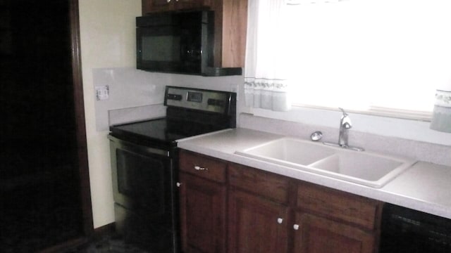 kitchen with a wealth of natural light, sink, and black appliances