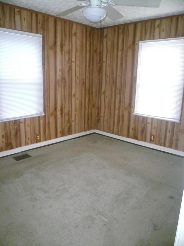 carpeted spare room featuring a textured ceiling and ceiling fan