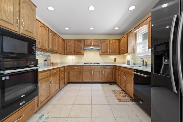 kitchen with black appliances, light tile patterned flooring, and sink