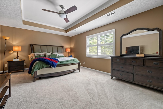 carpeted bedroom with a raised ceiling and ceiling fan