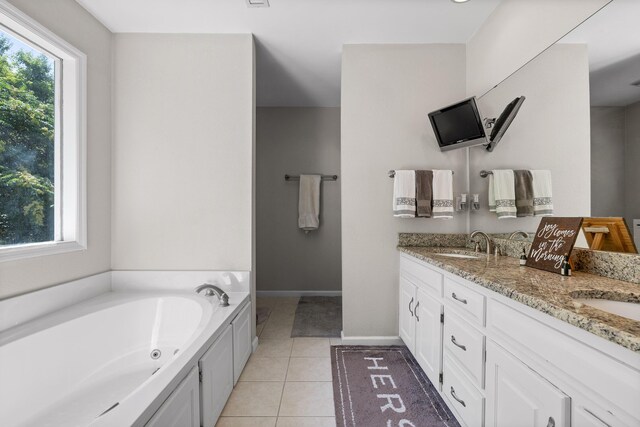 bathroom featuring vanity, a bathtub, tile patterned floors, and a wealth of natural light