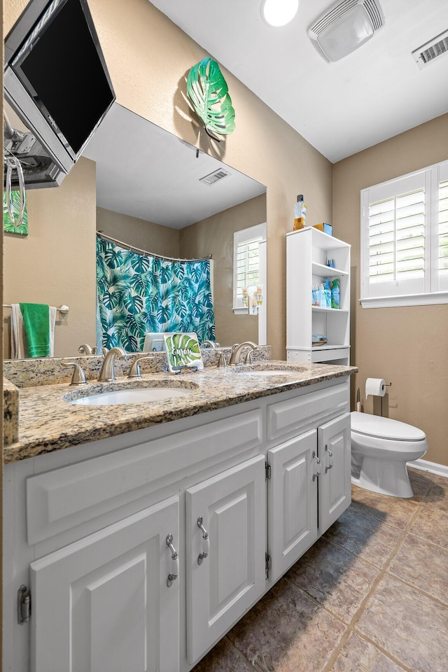 bathroom with vanity, a shower with shower curtain, and toilet