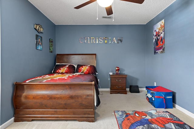 carpeted bedroom featuring ceiling fan and a textured ceiling