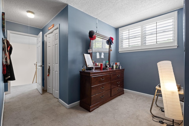 interior space with light carpet, a closet, and a textured ceiling