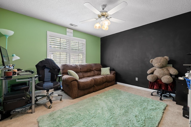 home office featuring ceiling fan, light colored carpet, and a textured ceiling