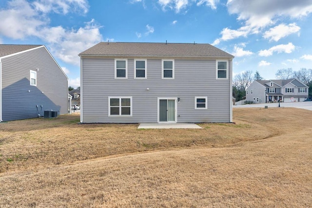 back of property with central air condition unit, a yard, and a patio