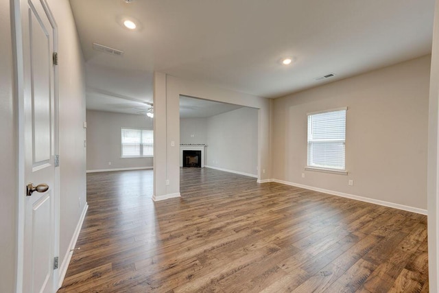 unfurnished living room featuring ceiling fan and dark hardwood / wood-style floors