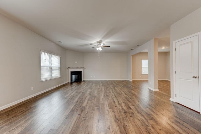 unfurnished living room with hardwood / wood-style flooring, plenty of natural light, and ceiling fan