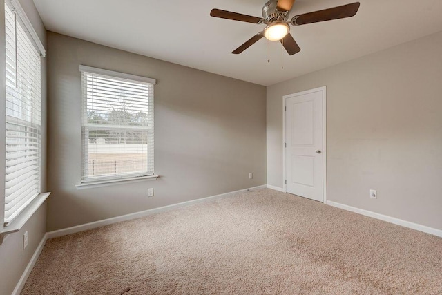 carpeted spare room with ceiling fan