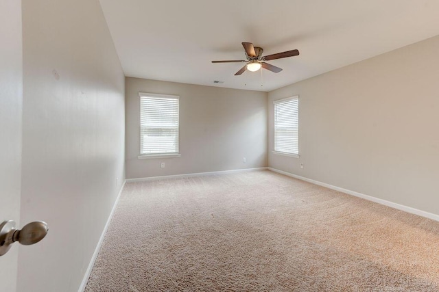 empty room featuring ceiling fan, a healthy amount of sunlight, and light carpet