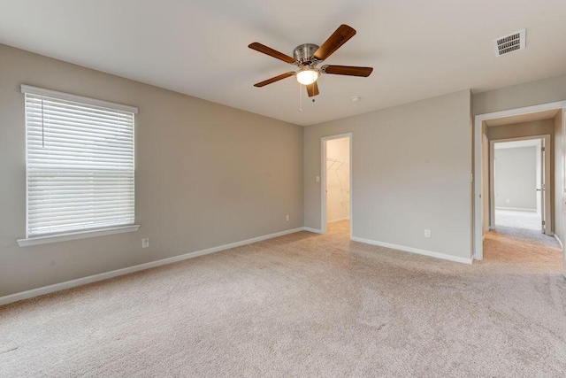 carpeted spare room with ceiling fan