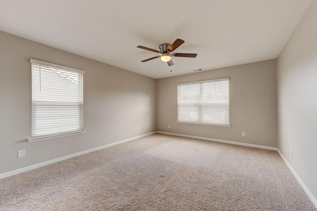 carpeted empty room featuring a wealth of natural light and ceiling fan