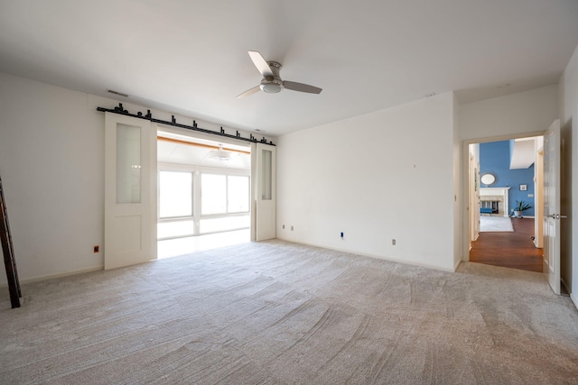 carpeted spare room with ceiling fan