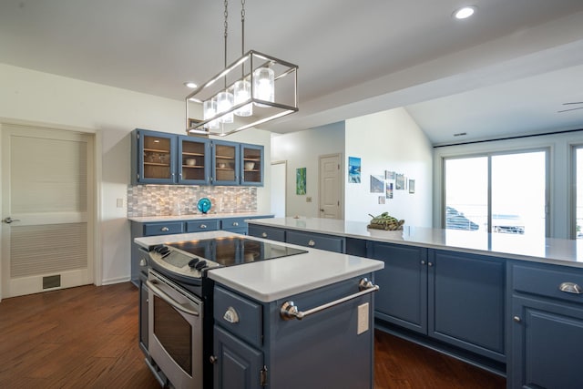 kitchen with decorative backsplash, stainless steel electric stove, blue cabinetry, and a center island