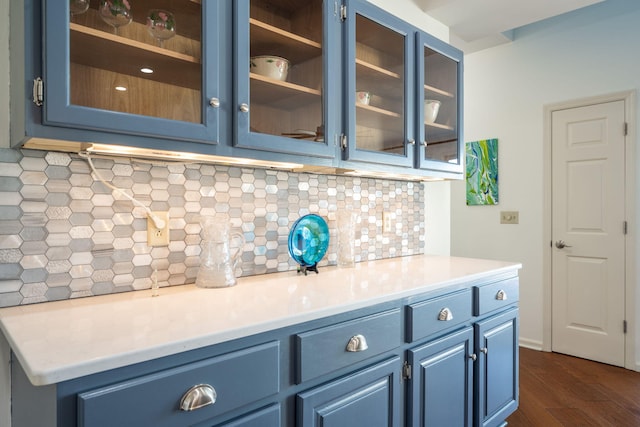 kitchen with dark hardwood / wood-style floors, backsplash, and blue cabinetry