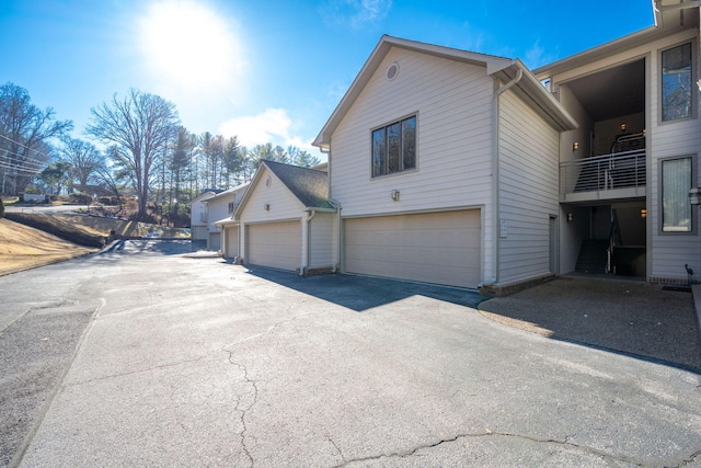 view of side of property featuring a balcony and a garage