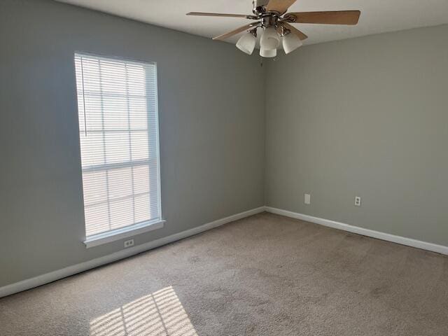 spare room with ceiling fan and light colored carpet