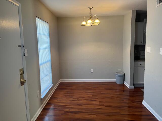 interior space with a notable chandelier and dark hardwood / wood-style floors