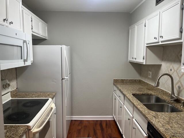 kitchen with stone counters, sink, white cabinets, and white appliances