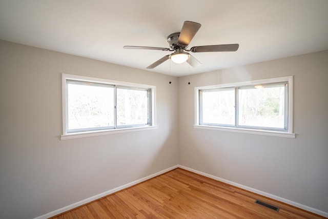 empty room featuring ceiling fan, light hardwood / wood-style floors, and a wealth of natural light