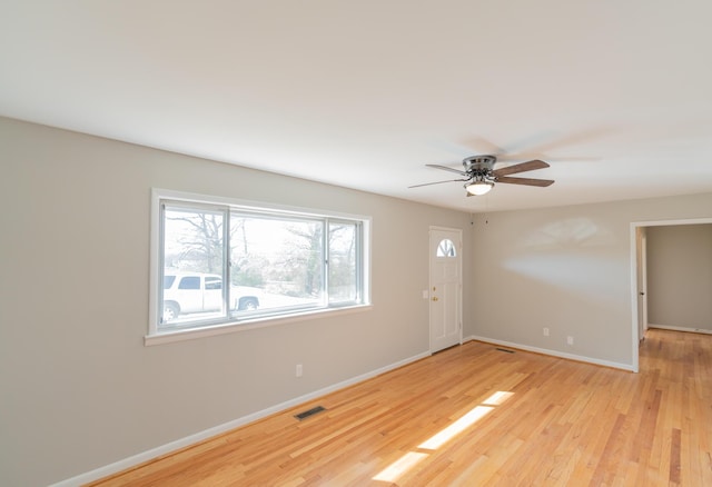 empty room with ceiling fan and light hardwood / wood-style flooring