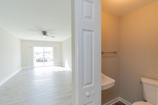 bathroom with hardwood / wood-style floors, ceiling fan, and toilet