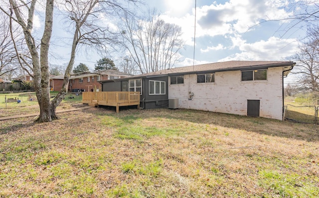 back of property featuring a wooden deck, a lawn, and central air condition unit