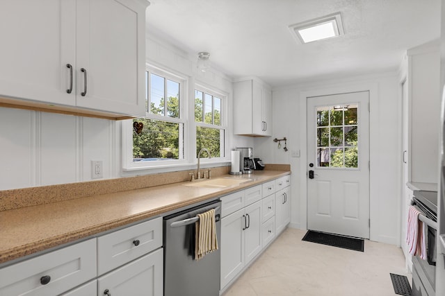 kitchen with dishwasher, stove, white cabinetry, and sink