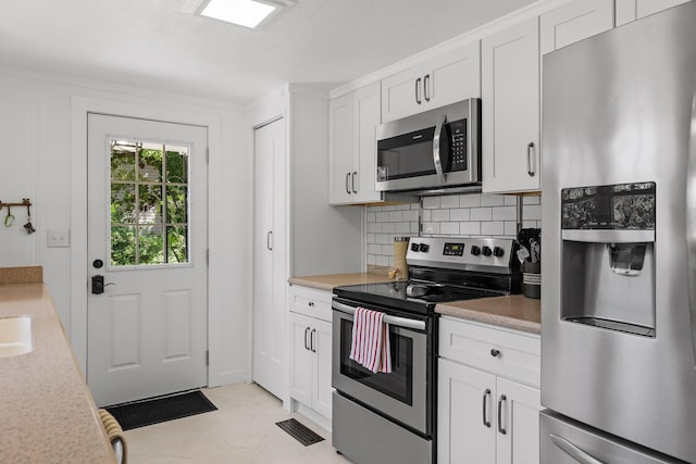 kitchen with appliances with stainless steel finishes, tasteful backsplash, and white cabinetry