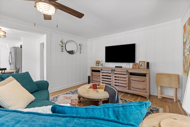 living room with hardwood / wood-style flooring, ceiling fan, and crown molding