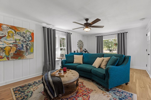 living room featuring ceiling fan, light hardwood / wood-style floors, and a healthy amount of sunlight