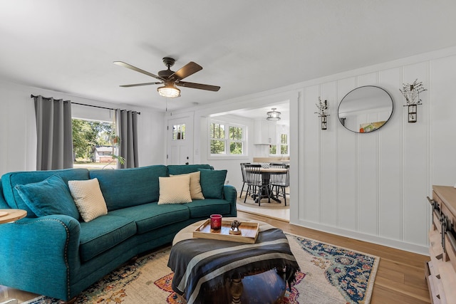 living room featuring light wood-type flooring and ceiling fan