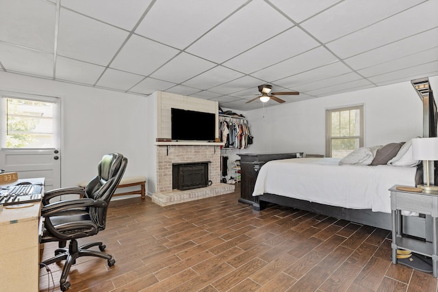 bedroom featuring multiple windows, ceiling fan, and a drop ceiling