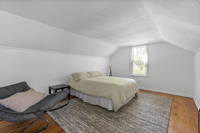 bedroom with lofted ceiling and dark wood-type flooring