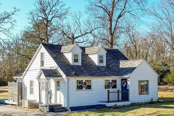 cape cod-style house with a front yard and central AC