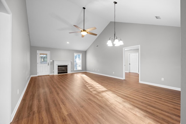 unfurnished living room featuring hardwood / wood-style floors, ceiling fan with notable chandelier, and high vaulted ceiling