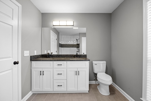 bathroom featuring a tile shower, tile patterned flooring, vanity, and toilet