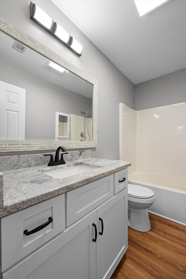 full bathroom featuring tasteful backsplash, vanity, toilet, shower / bathing tub combination, and hardwood / wood-style flooring