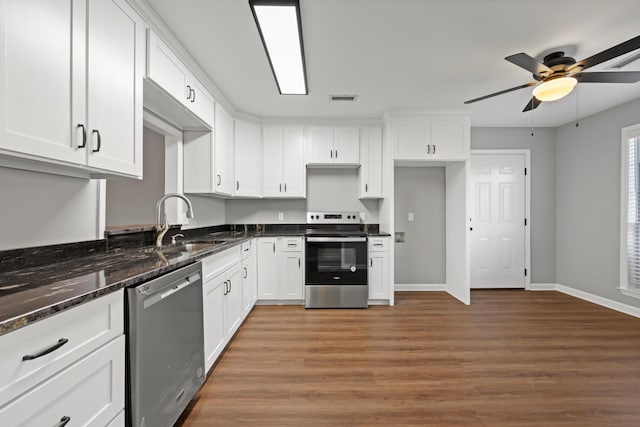 kitchen featuring white cabinets, appliances with stainless steel finishes, and dark stone countertops