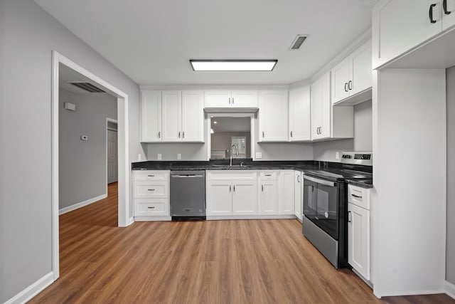 kitchen featuring hardwood / wood-style flooring, white cabinetry, sink, and appliances with stainless steel finishes