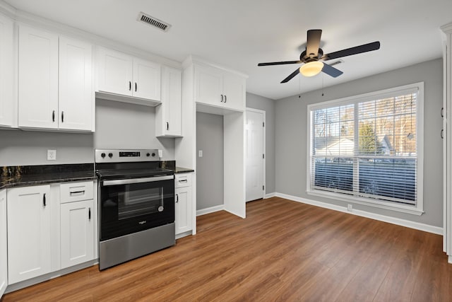 kitchen with stainless steel electric stove, ceiling fan, white cabinets, and dark hardwood / wood-style floors