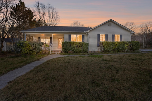 ranch-style home featuring a lawn and covered porch