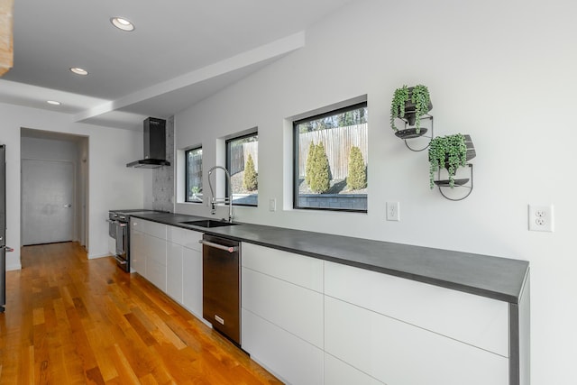 kitchen with wall chimney exhaust hood, sink, stainless steel electric range, dishwasher, and white cabinets