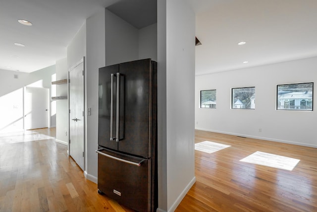 kitchen with high end black refrigerator and light hardwood / wood-style floors