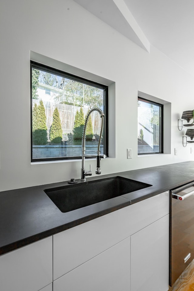 kitchen featuring white cabinetry, dishwasher, and sink