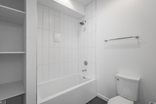 bathroom with tiled shower / bath, tile patterned floors, and toilet