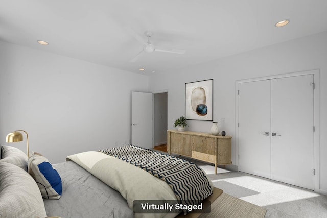 carpeted bedroom featuring ceiling fan and a closet