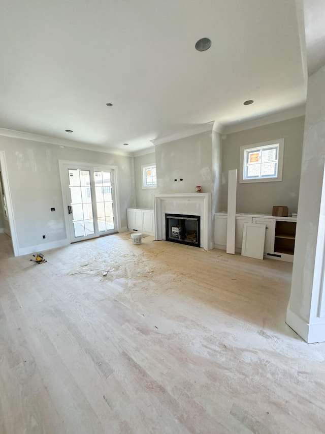 unfurnished living room featuring ornamental molding