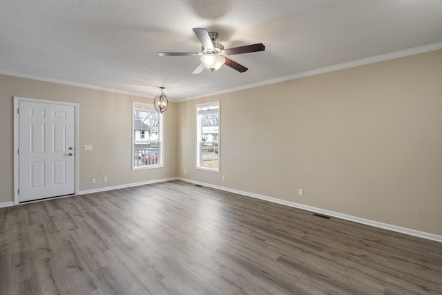 spare room featuring a textured ceiling, ceiling fan with notable chandelier, wood-type flooring, and ornamental molding